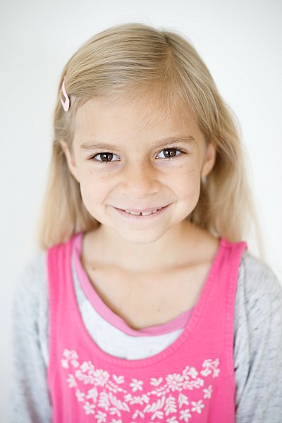 Blonde girl wearing pink and gray short for school portraits